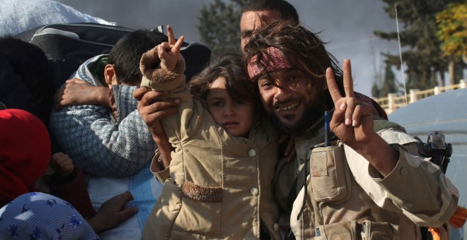 Un combatiente rebelde con una niña en Alepo (Siria). REUTERS/Ammar Abdullah
