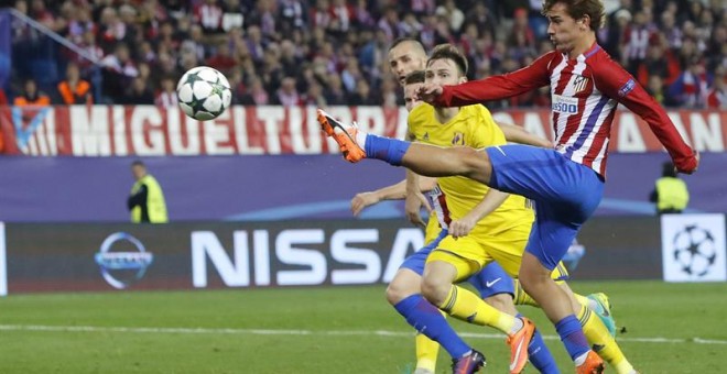 El delantero francés del Atlético de Madrid, Antoine Griezmann (d), se dispone a golpear el balón ante el defensor del Rostov, consiguiendo el segundo gol del equipo rojiblanco, durante el encuentro correspondiente a la cuarta jornada de la fase de grupo