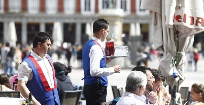 Un par de camareros atienden una terraza de un establecimiento en la Plaza Mayor de Madrid. E.P.