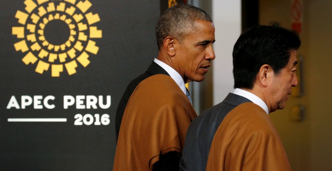El presidente estadounidense Barack Obama y el primer ministro japonés Shinzo Abe, ambos ataviados con típicos chales peuranos, antes de posar para la foto de familia de la cumbre de la APEC en Lima Perú). REUTERS/Kevin Lamarque