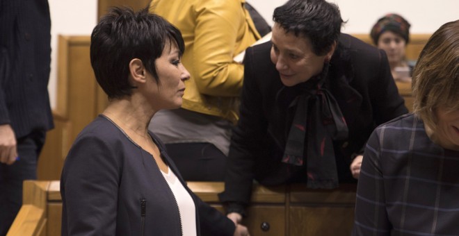 La candidata de EH Bildu, Maddalen Iriarte (d), conversa en el Parlamento Vasco con la diputada de su mismo grupo, Jone Goirizelaia (i), momentos antes de exponer su proyecto en el pleno de investidura, al que también se presenta el Lehendakari en funcion