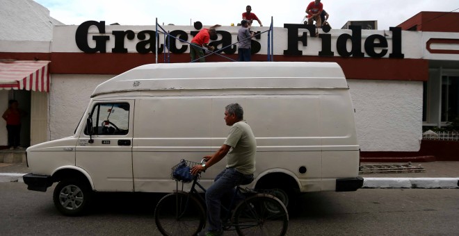 Unos trabajadores cuelgan un mensaje que dice 'Gracias Fidel' en la pared de un establecimiento en Santa Clara. REUTERS