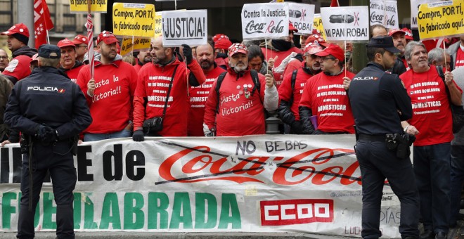 Trabajadores de Coca-Cola durante la concentración que han protagonizado ante la sede nacional del PP, en la que han estado acompañados por el líder de Podemos, Pablo Iglesias. EFE/Chema Moya
