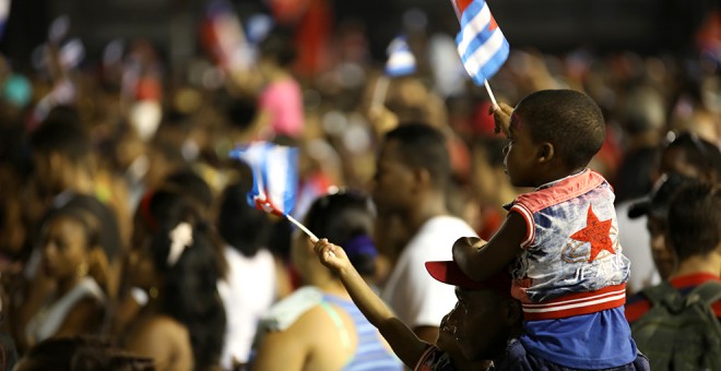 Un padre con sus dos hijos viendo los discursos.- MARIÁN LEÓN