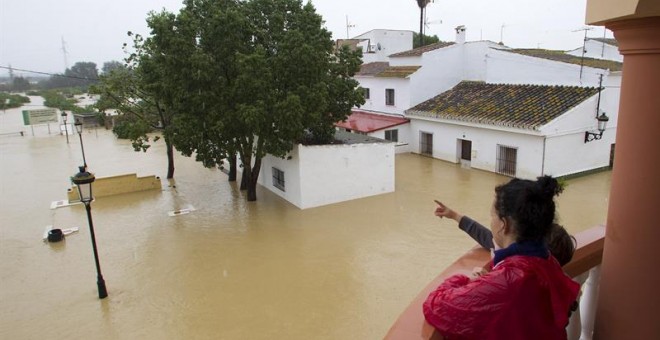 Varias personas observan el estado de sus casas inundadas en la barriada Doña Ana de la localidad de Cártama.- Daniel Pérez (EFE)