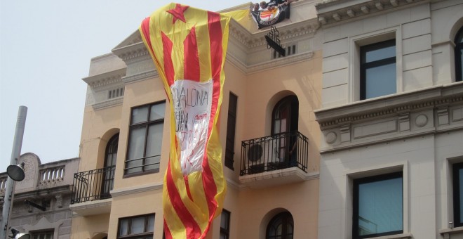 Varias personas despliegan una estelada en un edificio en Badalona,