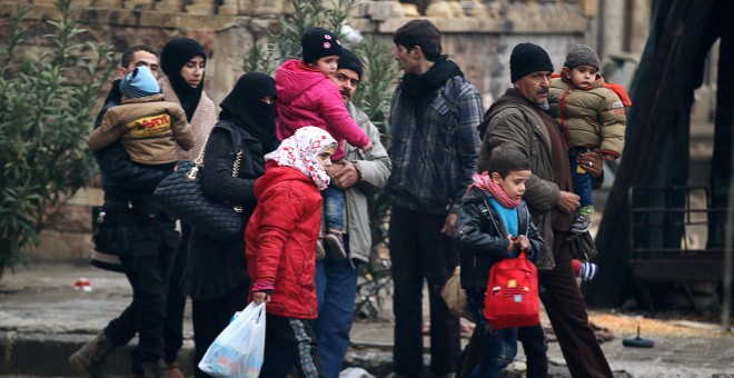 Un grupo de residentes de Alepo cargan con sus pertenencias para salir de la parte asediada de la ciudad. - REUTERS