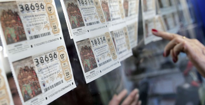 Una lotera de una administración de Valencia toma varios décimos del sorteo de Navidad. EFE/Manuel Bruque