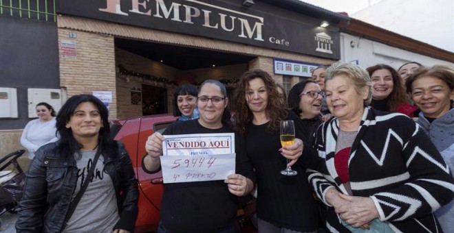 La vendedora de un cuarto premio de la loteria de navidad, el número 59.444, Cristina Canovas (2i), junto a su suegra, dueña del café el Templo, Josefina Moreno (c), celebran la venta del número acompañados de vecinos, hoy en Rincón de Seca, Murcia./EFE