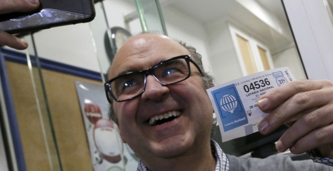 El administrador de lotería Óscar de Toro, se hace un selfie con el número agraciado con el segundo premio de la Lotería de Navidad, 4.536, vendido en su administración situada en un bar, esta mañana en Santiago de Compostela. EFE/lavandeira jr.