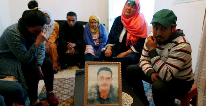 La familia de Anis Amri junto a una foto del presunto terrorista de Berlín.- EFE/Mohamed Messara