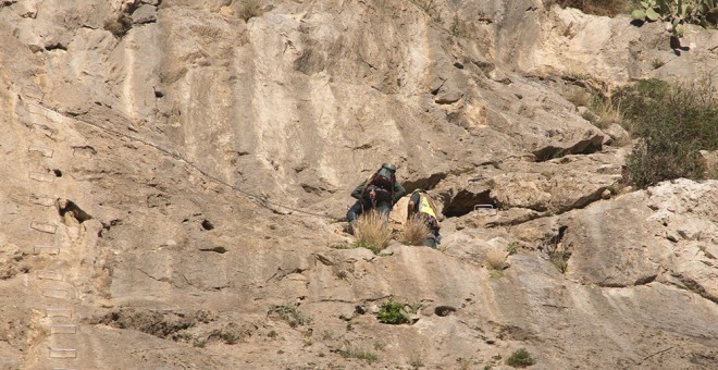 Miembros de los equipos de rescate en el lugar donde ha fallecido una joven tras caer desde una altura considerable, cuando estaba haciendo escalada en el paraje conocido como Tajo de los Vados, en Vélez Benaudalla (Granada). EFE/PAQUET