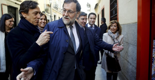 El presidente del Gobierno y del del Partido Popular, Mariano Rajoy, acompañado por Rafael Hernando, y de varios diputados de su formación en un bar proximo al Congreso de los Diputados tras la reunión que el grupo parlamentario popular ha celebrado en el