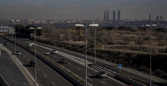 Vista de una carretera de circunvalación de Madrid sin apenas coches con las cuatro torres de la Castellana de fondo ayer. /EFE