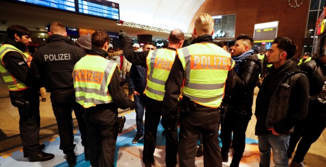 Agentes de Policía interrogan a jóvenes en la principal estación de trenes de Colonia. /REUTERS