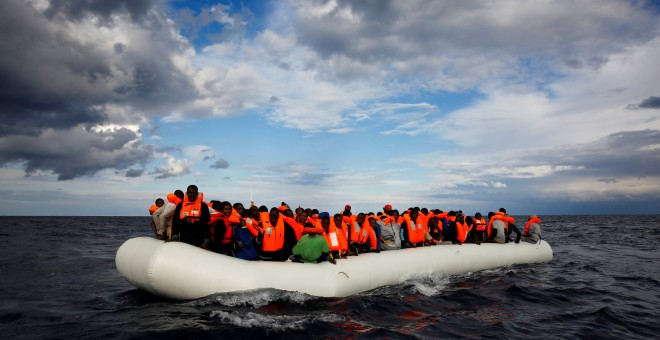 Una embarcación cargada de personas flota a la deriva en el Mediterráneo antes de ser rescatada por el barco de Proactiva Open Arms.- REUTERS/Yannis Behrakis