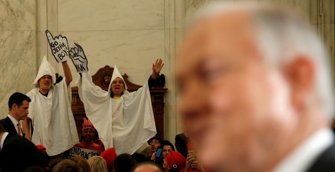 Manifestantes disfrazados del miembros del Ku Klux Klan protestan en la comparecencia de Jff Sessions en el Senado. /REUTERS