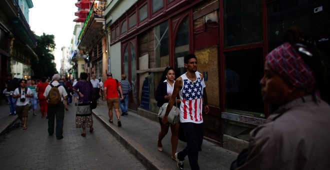 Un hombre cubano camina por las calles de La Habana con una camiseta  con la bandera estadounidense. / REUTERS