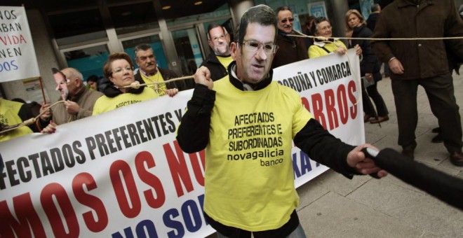 Dos afectados por las preferentes, con máscaras de Feijóo y Rajoy, durante una protesta. / EFE
