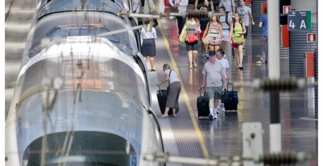 Estación con tren AVE y viajeros de Renfe. E.P.