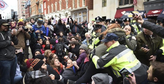 La policía ayuda a varias personas que trataban de asisitir al desfile de investidura y que han sido bloqueados por los manifestantes ubicados en la avenida Pennsylvania. - EFE