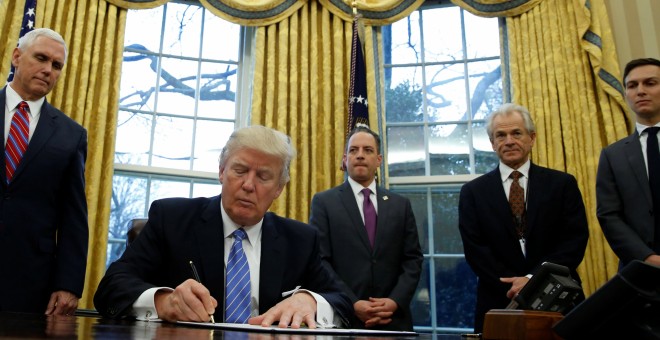 El presidente de EEUU, Donald Trump, firma la salida del tratado comercial TPP, en un acto en el Despacho Oval, ante la presencia del vicepresidente, Mike Pence; su jefe de gabinete, Reince Priebus, y dos de sus asesores más cercanos, Steve Bannon y su ye