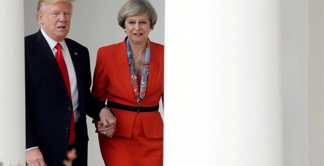 El presidente de EEUU, Donald J. Trump, pasea de la mano con la primera ministra británica, Theresa May, entre las columnas de la Casa Banca. EFE/EPA/Olivier Douliery