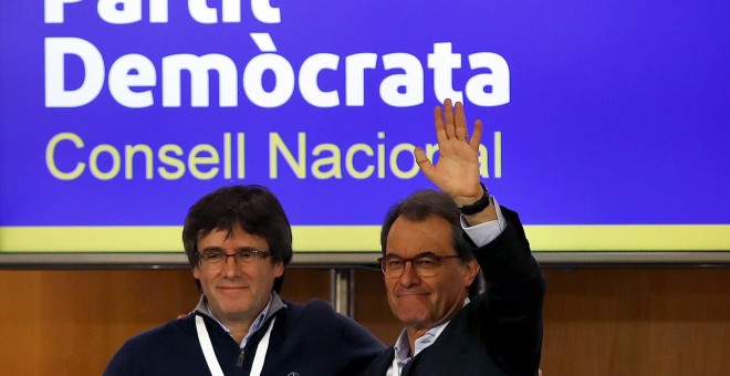 El presidente de la Generalitat, Carles Puigdemont, saluda al expresidente Artur Mas, tras su intervención ante el consell nacional del PDeCat. EFE/Alberto Estévez