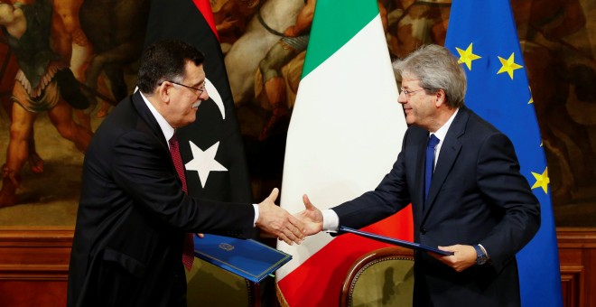 El primer ministro italiano Paolo Gentiloni (D) y su homólogo libio Fayez al-Sarraj se dan la mano después de firmar un acuerdo bilateral durante una reunión en Palacio de Chigi en Roma, Italia, el 2 de febrero de 2017.- REUTERS / Tony Gentil