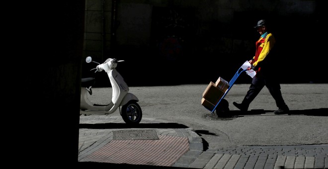 Un repartidor durante su jornada de trabajo en Madrid.-  REUTERS/Juan Medina