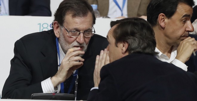 El presidente del Gobierno y del PP, Mariano Rajoy, conversa con el portavoz del PP en el Congreso, Rafael Hernando, durante el el XVIII Congreso nacional del partido que se ha inaugurado en la Caja Mágica de Madrid. EFE/Javier Lizón