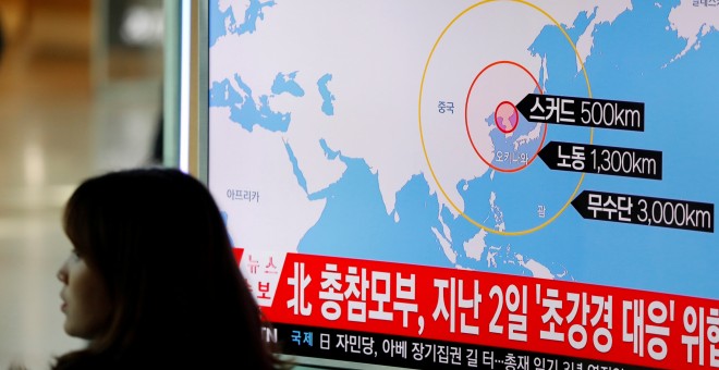 Una mujer pasa junto a una televisión en Seúl donde se informa del lanzamiento de misiles de Corea del Norte. - REUTERS