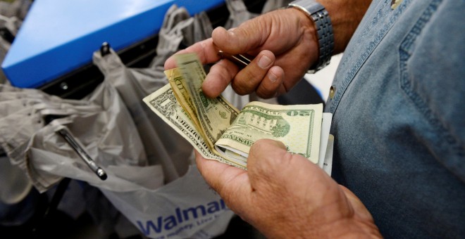 Un cliente cuenta su dinero en la caja de un supermercado de la cadena Walmart en Los Angeles. REUTERS/Kevork Djansezian