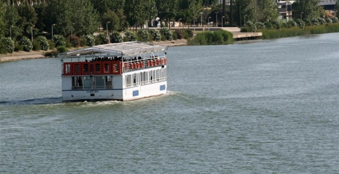 Una barcaza por el río Guadalquivir a su paso por Sevilla. E.P.