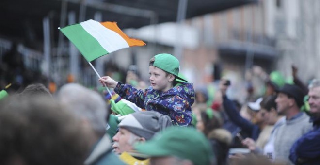 Un niño porta una bandera de Irlanda durante la celebración de la festividad de San Patricio. EFE/Aidan Crawley