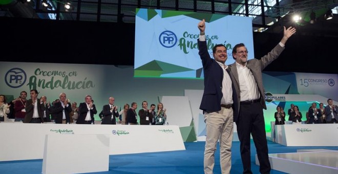El presidente del Gobierno, Mariano Rajoy (d), y el líder del PP andaluz, Juanma Moreno (i), saludan tras finalizar la intervención del jefe del Ejecutivo, durante la clausura del 15 Congreso Autonómico del Partido Popular que se ha celebrado este fin de