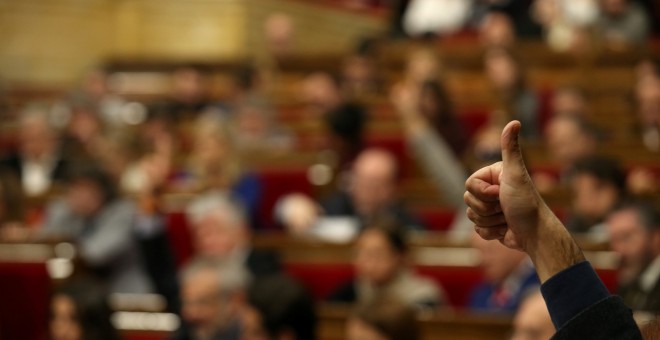 Un diputado indica el sentido del voto a su grupo durante la votación en el Pleno del Parlament de los Presupuestos catalanes para 2017. REUTERS/Albert Gea