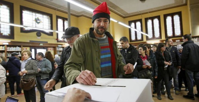 Un ciudadano, con barretina, deposita su papeleta durante la jornada de votación del 9-N. EFE/Archivo