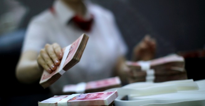 Una empresa del Banco Industrial y Comercial de China cuenta dinero en una sede del banco en Shanghai.REUTERS/Carlos Barria