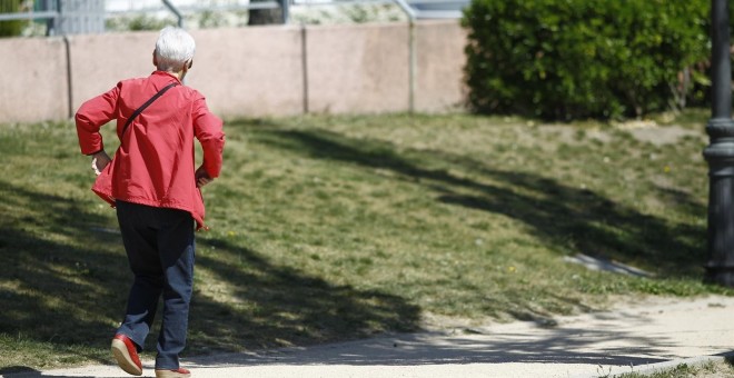 Una mujer mayor camina por un parque de Madrid. E.P.