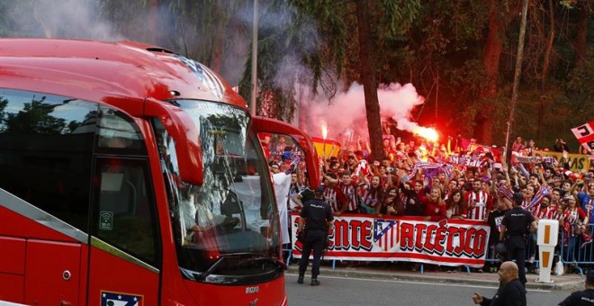 Cientos de aficionados del Atlético, algunos con bengalas, al paso del autobús de su equipo. /EFE