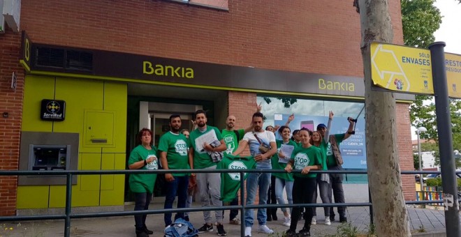 Activistas de la PAH Vallekas, frente a una sucursal de Bankia, tras un encierro para exigir la paralización de cuatro desahucios.- PAH VALLEKAS