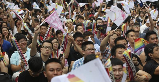 Dos integrantes de la comunidad LGBT se abrazan mientras celebran la decisión del Tribunal Constitucional sobre el matrimonio entre personas del mismo sexo ante el Parlamento en Taipei / EFE