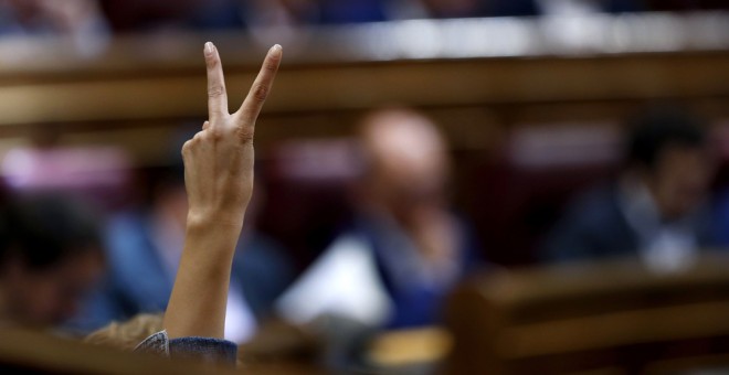 Una diputada socialista indica con los dedos levantados el sentido de la votación durante la última jornada de debate en el Pleno del Congreso de los Presupuestos Generales del Estado de 2017. EFE/Chema Moya