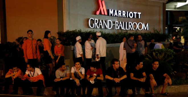 Empleados del Resort World evacuados, en la entrada de un hotel cercano, en Manila. REUTERS/Erik De Castro