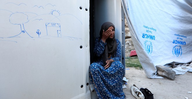 Aanoud, 47, se sienta frente a su refugio en el campo de refugiados de Souda, en Grecia. Su marido migró a Alemania hace dos años y ella solicitó la reunificación familiar, pero sólo dos de sus cuatro hijos fueron aceptados. 'Sigo esperando a la decisión