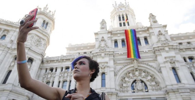 Una mujer se fotografía junto a la fachada del Ayuntamiento de Madrid donde hoy se ha desplegado la bandera del orgullo gay en una semana en la que tendrá lugar la celebración del World Pride 2017, en la capital española. EFE/Juan Carlos Hidalgo