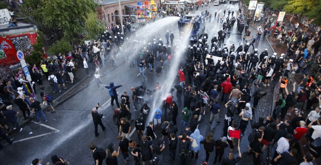Camiones de Policía dispersan a los manifestantes con chorros de agua a presión. /REUTERS