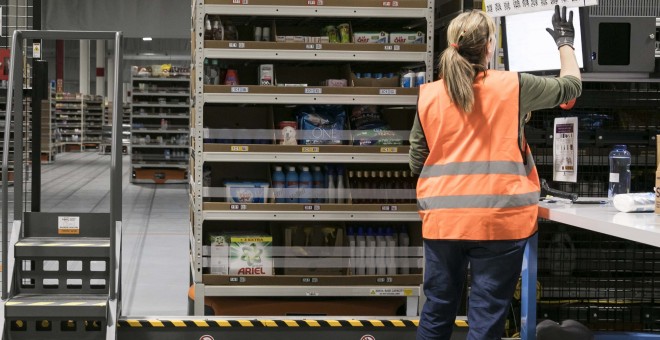 Una trabajadora de Amazon almacena y etiqueta mercancía con códigos QR.