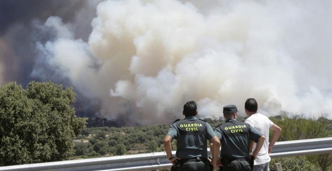 Agentes de la Guardia Civil observan el incendio forestal que se ha producido en la localidad zamorana de Pino del Oro y que la Junta de CyL ha declarado nivel 2 por la cercanía a la Nacional 122. EFE/Mariam A. Montesinos